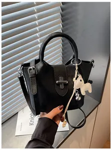 Vue détaillée du sac seau noir au design de niche avec un porte-clé cheval blanc