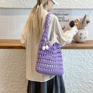 Bolso de hombro casual de ganchillo morado con dijes de tulipán en un entorno de café