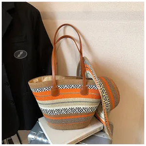Detailansicht einer gestreiften Stroh-Strandtasche mit einem passenden modischen Sommerhut