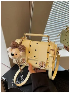 Close-up of a retro cream yellow polka dot handbag with a cute teddy bear charm
