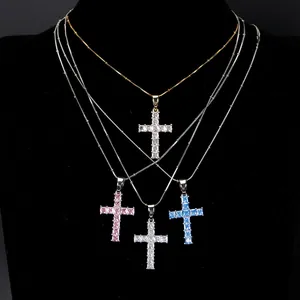 Macro detail of hip-hop style cross pendant necklaces featuring vibrant crystal stones