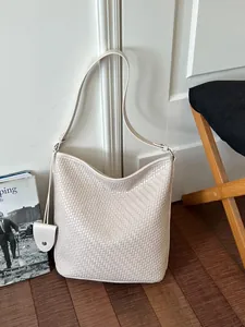 Vintage beige geweven hobo bucket bag met een ruim interieur en een lange verstelbare riem