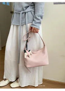 Chic pink leather hobo shoulder bag with cute pegasus charm, minimalist Korean style detail.