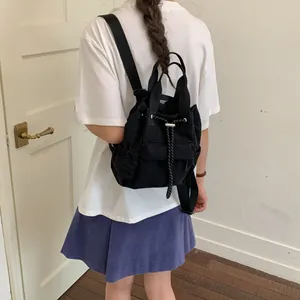 Primer plano de la mochila negra con cordón usada como una bolsa versátil diaria