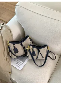 Dos elegantes bolsos de lona con ribete azul sobre un sofá, vista de detalle.
