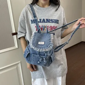 Elegante mini zaino in denim vintage con volant in pizzo indossato da una modella.