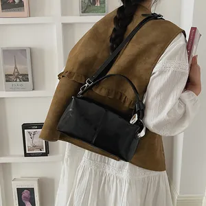 Back view of model wearing a vintage black glossy pillow bag with niche design details