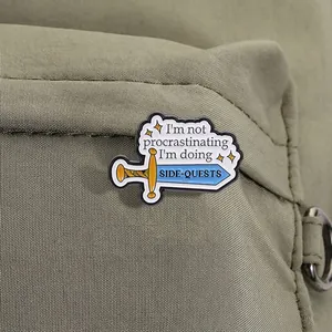 Gros plan d'un pin's en émail épée avec texte side-quest sur un sac