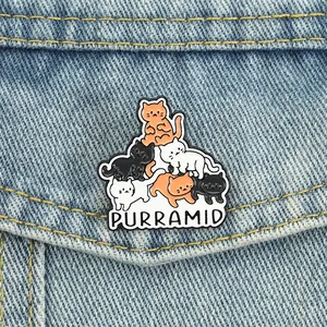 Detailansicht eines Purramid-Katzen-Emaille-Pins auf Denim mit bunten Kätzchen.