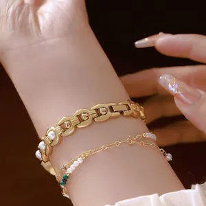 Vista dettagliata di un elegante bracciale vintage a maglie dorate con perle bianche