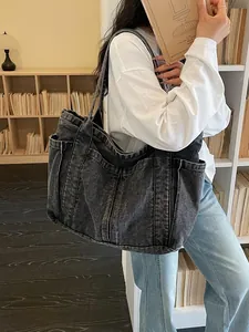 Grand sac cabas en denim délavé vintage avec poches extérieures pour un style citadin.