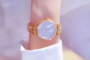 Primer plano del reloj dorado Bee Sister para mujer con esfera de pedrería estrellada