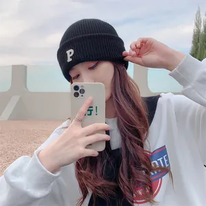 Fashionable Asian model wearing a black knitted beanie with a white embroidered letter P