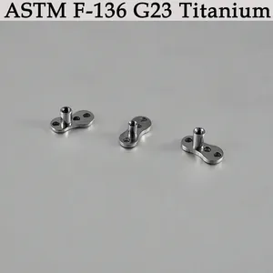 Detailed view of three G23 titanium dermal anchor bases with ASTM F-136 material mark