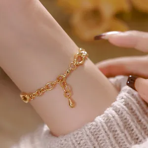 Primo piano di un bracciale a catena dorato in stile vintage con ciondolo a goccia