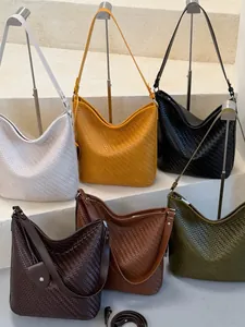 Grote gevlochten hobo-emmertassen in verschillende kleuren op trappen getoond