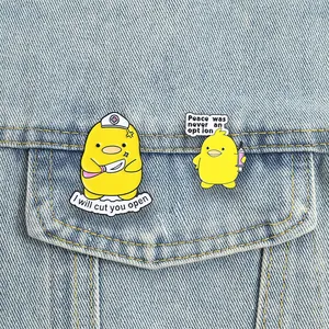Close-up detail of funny medical-themed yellow duck enamel pins pinned on a denim jacket pocket.