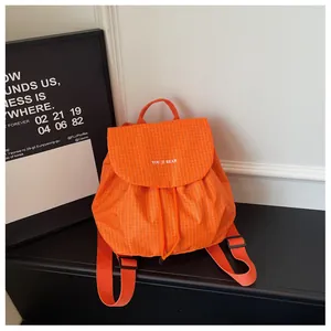 Detail view of the orange checkered drawstring backpack with You Ji Bear logo.