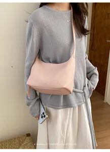 Pink leather hobo bag detailed view worn by a female model