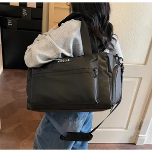Large black waterproof travel duffel bag for fitness and short trips shown on model