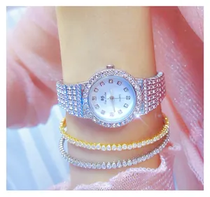 Primer plano de un reloj de lujo de cristal plateado con pulseras en la muñeca