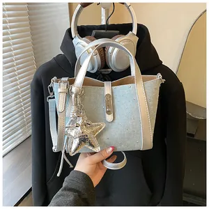 Detailed macro view of light blue denim bucket bag featuring rhinestones and star charm