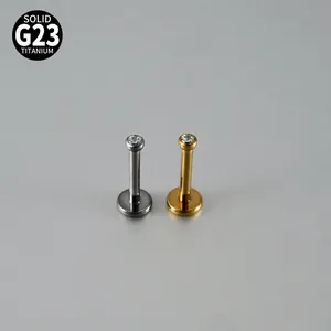 Detail of G23 titanium internally threaded labret studs with round zircon in gold and silver.