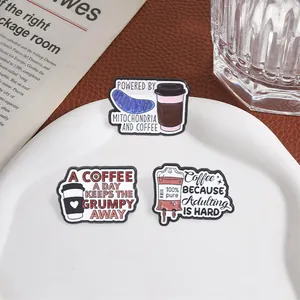 Humorous coffee themed enamel pins featuring mitochondria and adulting text quotes