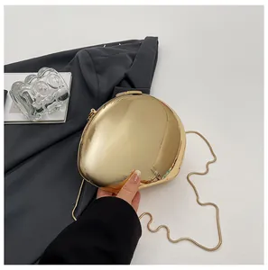 Primo piano di una borsa da sera dorata a specchio con tracolla a catena di lusso