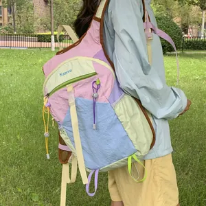 Close-up detail of the colorful dopamine style outdoor hiking backpack worn in a grassy park