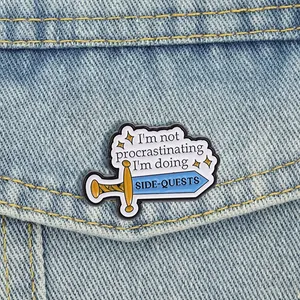 Détail du pin's en émail épée avec texte Side-Quests épinglé sur du denim bleu