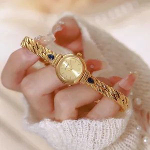Detalle de un reloj vintage dorado para mujer con circonitas azules y pulsera de eslabones