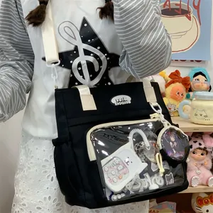 Detail view of black canvas ita bag with clear window shown on person
