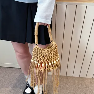 Detailed view of handmade macrame woven bucket bag with long tassels and wooden beads