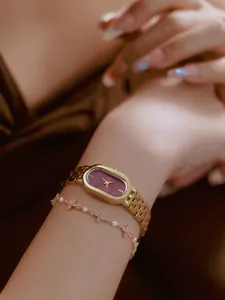 Elegante goldene Uhr mit burgunderfarbenem Zifferblatt und Schmetterlings-Armband.