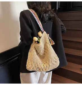 Vue détaillée du sac cabas en paille beige tissé main avec bandoulière à motifs ethniques