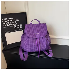 Stylish purple checkered small rucksack with drawstring closure and flap on display