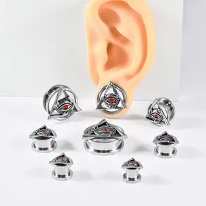 Detail view of stainless steel ear tunnels featuring an engraved All-Seeing Eye design