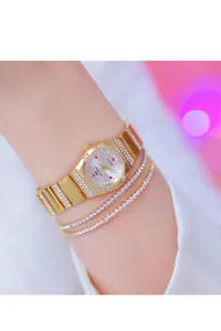 Gedetailleerde weergave van een elegant gouden dameshorloge en diamanten armbanden.
