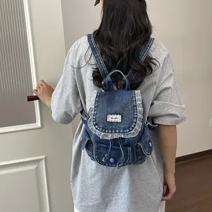 Dettaglio di un elegante zaino in denim retrò con bordi in pizzo indossato da una modella