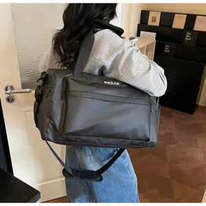 Close-up view of a large black duffle bag with adjustable shoulder strap for travel and gym