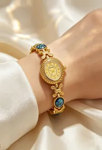 Detalle de elegante reloj brazalete dorado con incrustaciones de concha de abulón natural