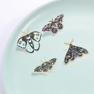 Set of 4 vintage mystical moth and butterfly enamel pins with moon and floral patterns.