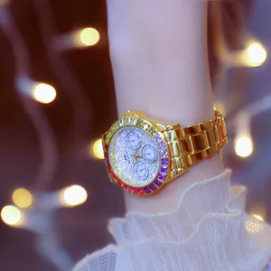 Close-up of a luxury women's gold watch with rainbow bezel and crystal-encrusted dial