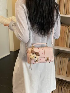 Vintage style pink polka dot crossbody handbag with a cute teddy bear charm for women