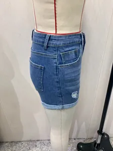 Vista lateral de un pantalón corto vaquero azul de talle alto con rotos de moda