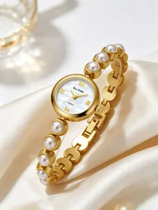 Elegante goldene Damenuhr mit einem Perlmuttzifferblatt und Armband aus Kunstperlen