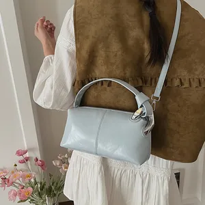Detail view of a light blue vintage pillow bag with silver knot handle on model.