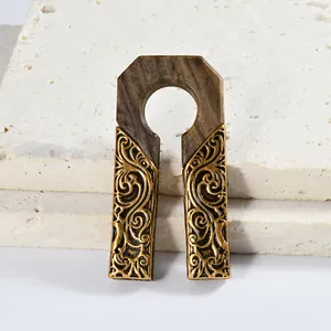 Vue détaillée du poids d'oreille en U avec bois sculpté et volutes dorées
