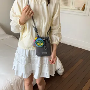 Stylish grey crossbody bucket bag for women featuring a cute banana charm accessory